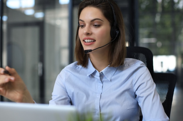 Woman customer support operator with headset and smiling.