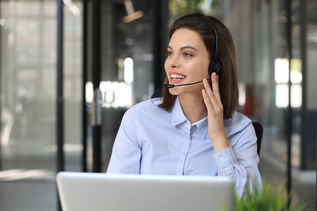 Woman customer support operator with headset and smiling.