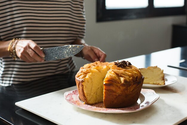 Woman cutting homemade apple pie at the kitchen