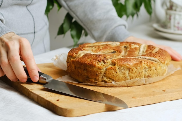 Woman cutting sweet banana bread cake