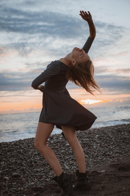 Woman dances on the seashore at sunset Psychology of soul and body dance grace