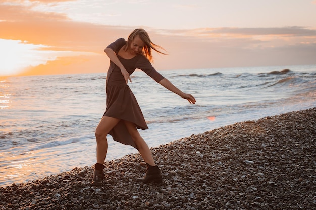 Woman dances on the seashore at sunset Psychology of soul and body dance grace