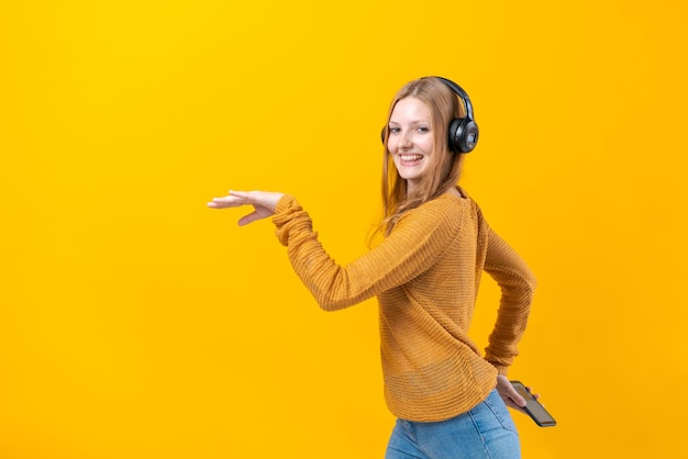 Woman dancing to music while listening to MP3 player with wired headphones