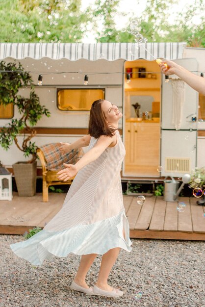 Woman dancing near trailer in bubbles