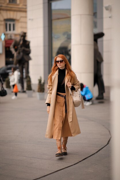 a woman in dark glasses crosses the road at a pedestrian crossing. woman in the city