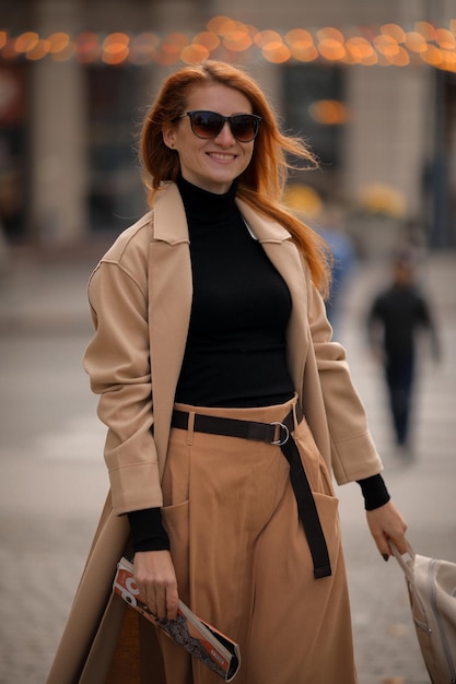 a woman in dark glasses crosses the road at a pedestrian crossing. woman in the city