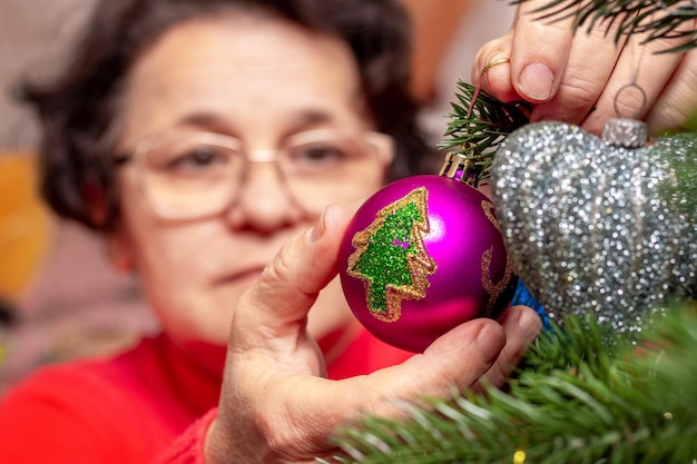 A woman decorates a Christmas and New Year tree Preparation for Christmas and New Year