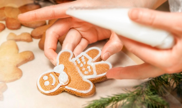 Woman decorates gingerbread man with icing