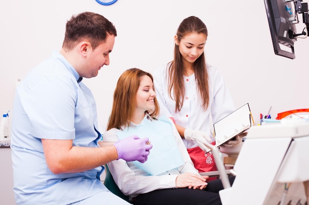 Woman in a Dentist office choosing color of her veneers