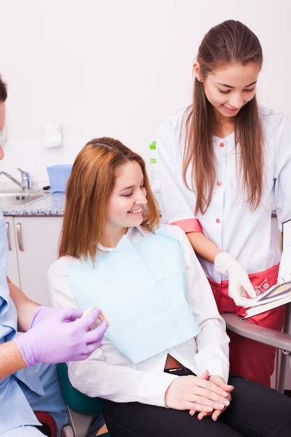 Woman in a Dentist office choosing color of her veneers