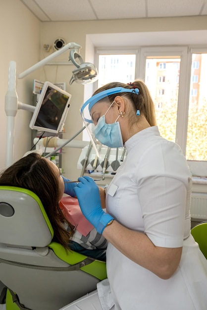 Woman at a dentist's appointment checks her teeth and gums caries prevention