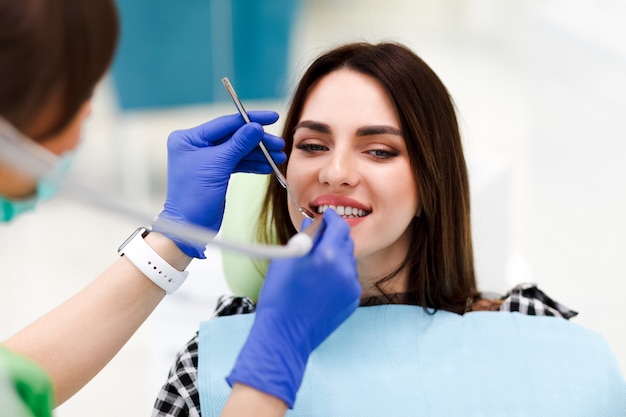 Woman at the dentistry Dentist treats teeth to his pretty patient. Dental doctor drills patient's teeth