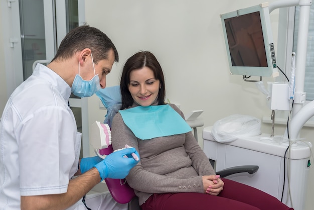 Woman in dentistry pointing at teeth sampler