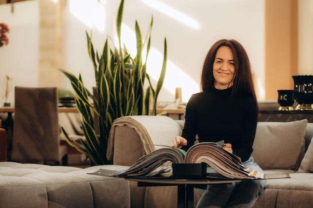 Woman designer at furniture store looking at textile swatch