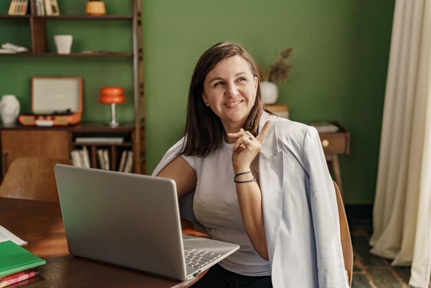 A woman designer works in a studio designs a new website online uses a laptop on the table