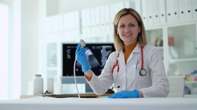 Woman doctor holding ultrasonic machine probe in clinic