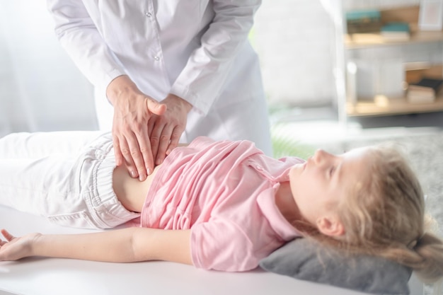 Woman doctor in the hospital or clinic examines young girls stomach Gastroenterology