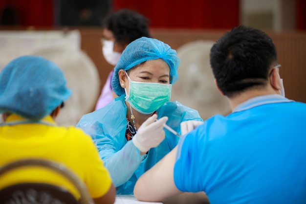 woman doctor injecting covid19 coronavirus vaccine for patient