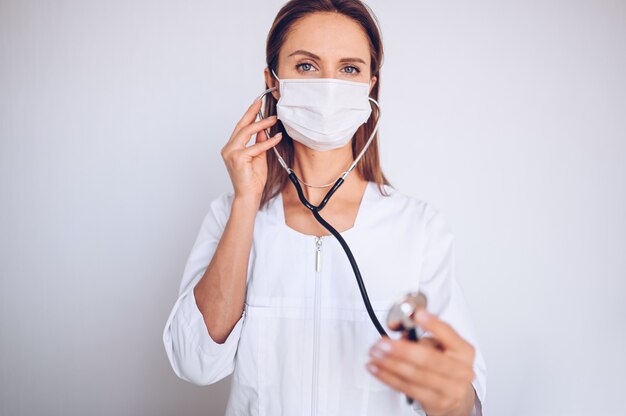 Woman doctor nurse wearing protective mask and stethoscope for check breathing, corona virus prevention, hygiene to stop spreading coronavirus. Avoid contaminating Corona virus Covid-19 concept