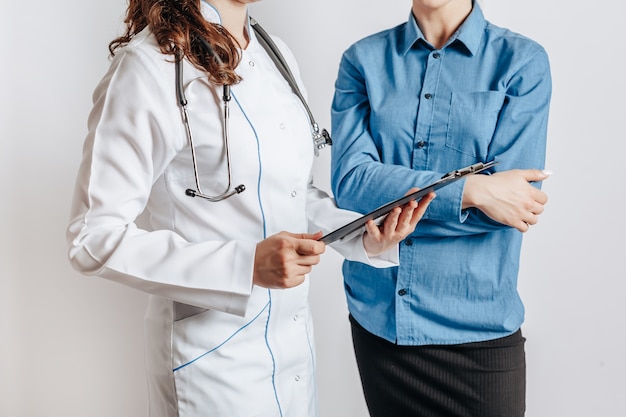 Woman at doctor at reception to check health isolated on gray