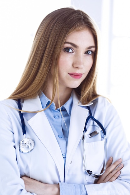 Woman doctor standing in hospital office. Physician at work, life portrait. Medicine and health care concept.