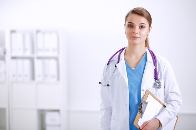 Woman doctor standing with folder at hospital