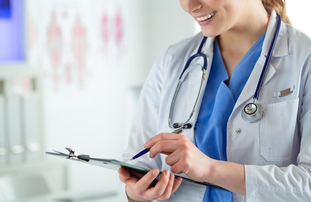 Woman doctor standing with folder at hospital