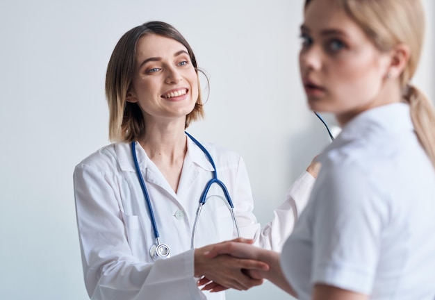 Woman doctor with glasses in hands on a light background patient communication