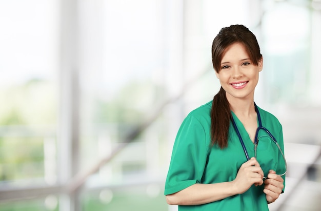 Woman doctor with stethoscope on background