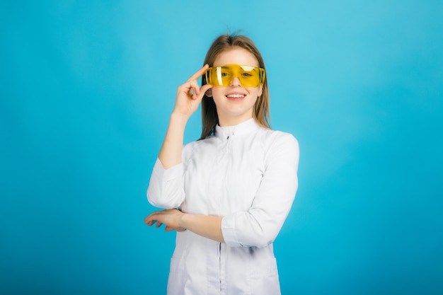 Woman doctor in yellow glasses on blue background