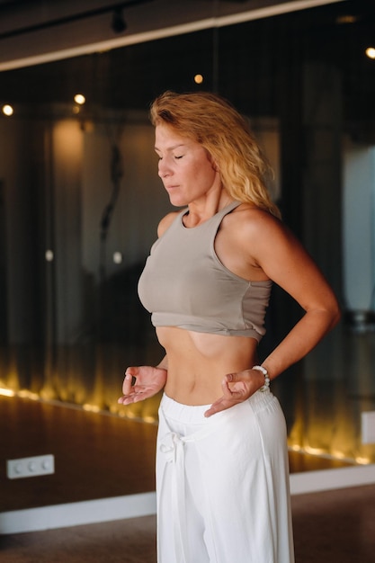 A woman does breathing exercises in the fitness room Home sports training for the muscles of the press