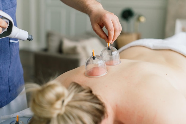 A woman does a hip massage with a vacuum jar for an anti-cellulite massage.