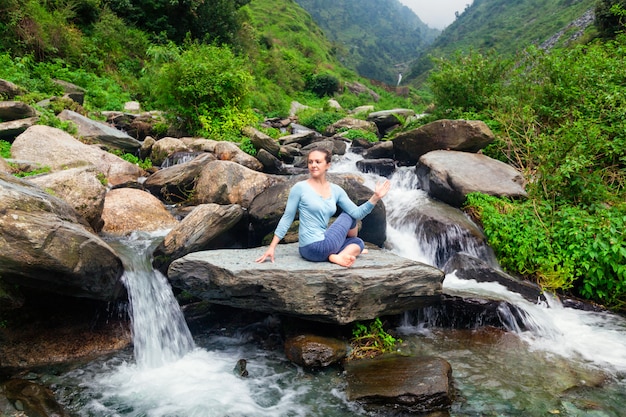 Woman doing Ardha matsyendrasana asana outdoors