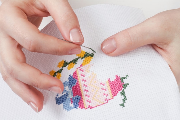 woman doing cross stitch. Egg and willow branches