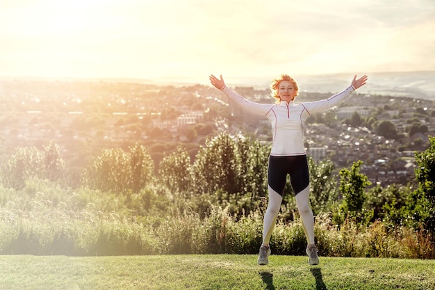 Woman doing exercises in the park against city