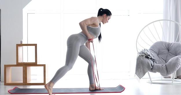 Woman doing exercises with resistance bands at home.