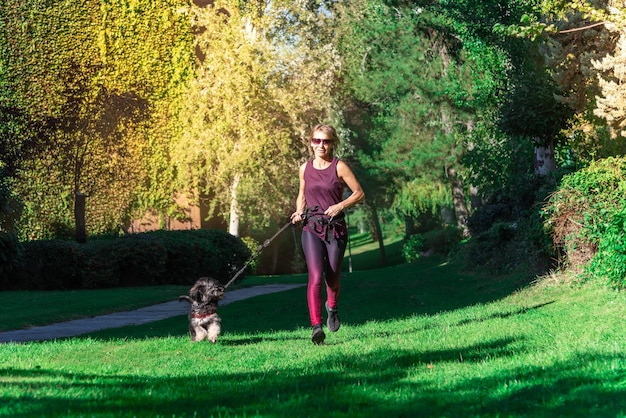 Woman doing sport with a Catalan shepherd dog using a leash for running with pets Sport with animals