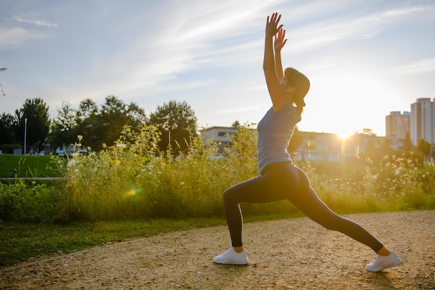 Woman doing sports in the countryside at sunset