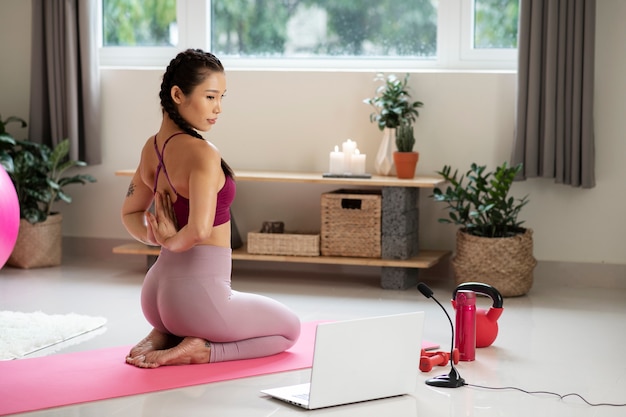 Woman doing yoga after online fitness instructor