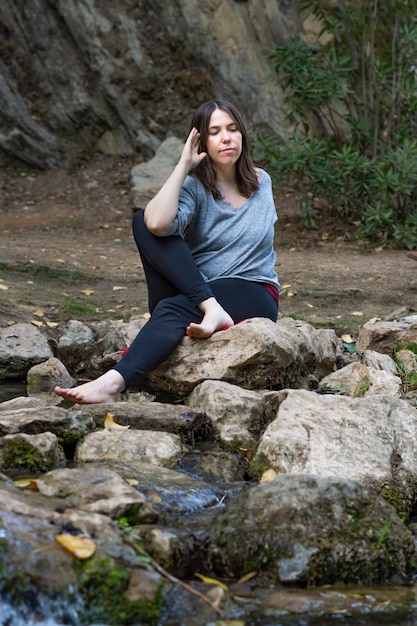 Woman doing yoga and meditation in a river