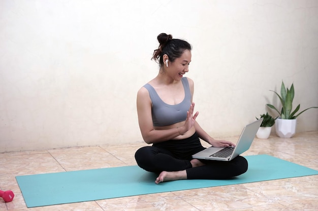 A woman doing yoga with online partner at home