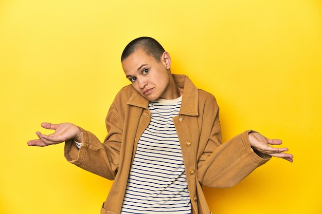 Woman doubting and shrugging shoulders in questioning gesture