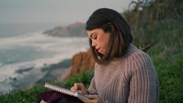 Woman drawing evening beach closeup girl artist making sketch gloomy seascape