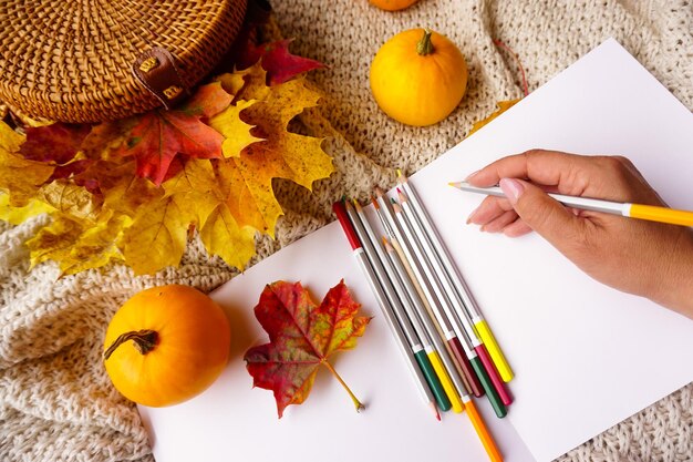 A woman draws in an album with watercolor pencils