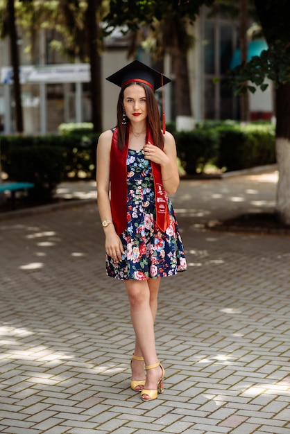 Photo a woman in a dress and cap stands on a brick walkway