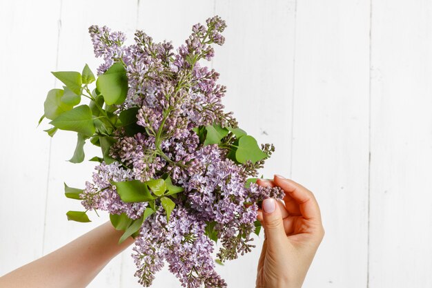 Woman in dress holding a big branch of lilac flower in her hand