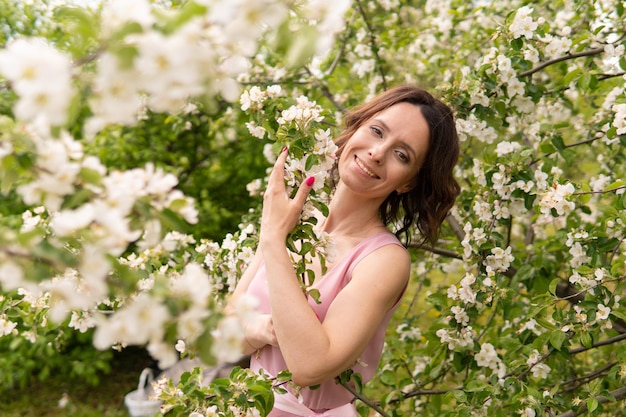 A woman in a dress near a blooming spring tree. Romantic happy mood.