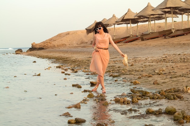 Woman in dress standing in water of sea