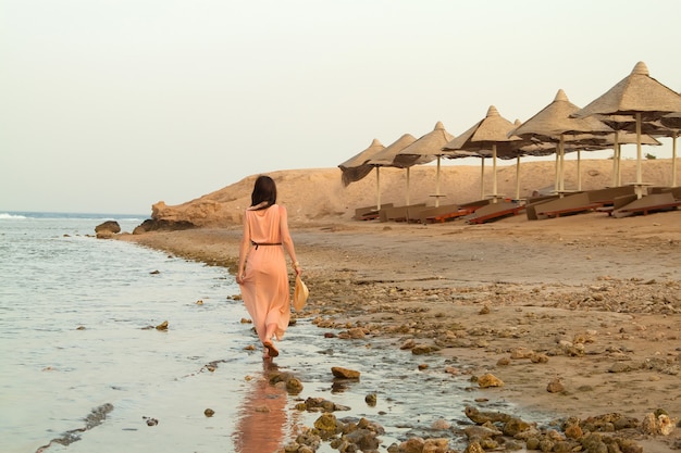 Woman in dress standing in water of sea