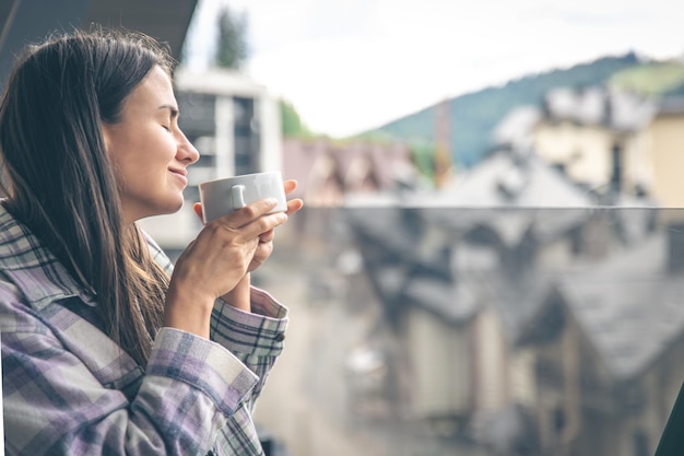 A woman drinking coffee on the balcony in the morning